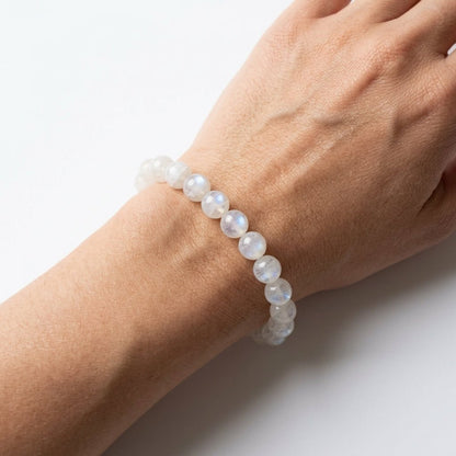 Moonstone bracelet on wrist featuring round light blue moonstone beads with soft glow