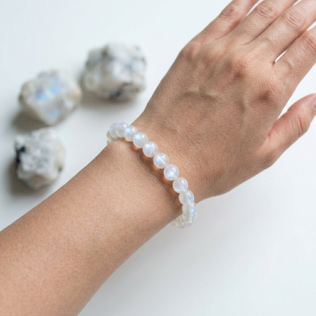 Moonstone bracelet worn on hand with round light blue moonstone beads on wrist