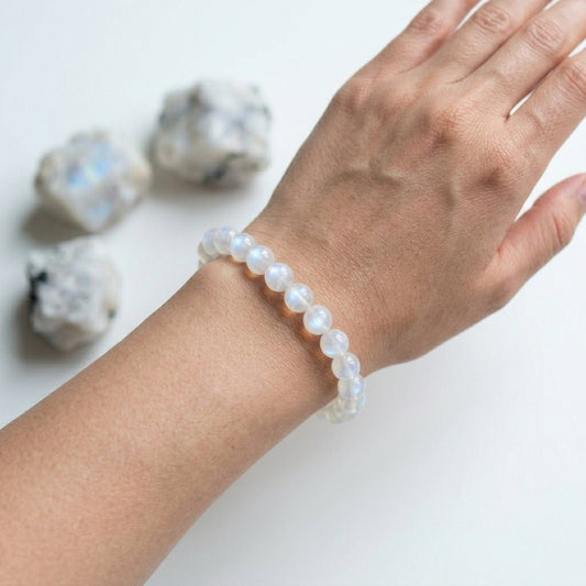 Moonstone bracelet worn on hand with round light blue moonstone beads on wrist