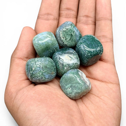 Natural moss agate tumble stones in hand, green and blue with natural banding