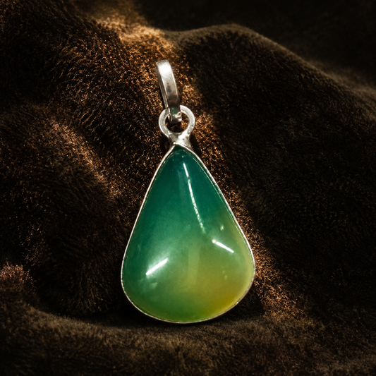 Multi-color onyx locket pendant with teardrop gemstone in silver-tone bezel on dark fabric