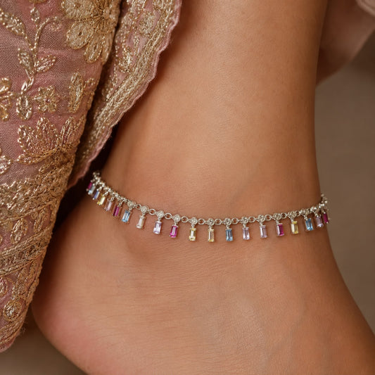 Multicolour baguette stone 925 sterling silver anklet with dangling charms on a woman’s ankle