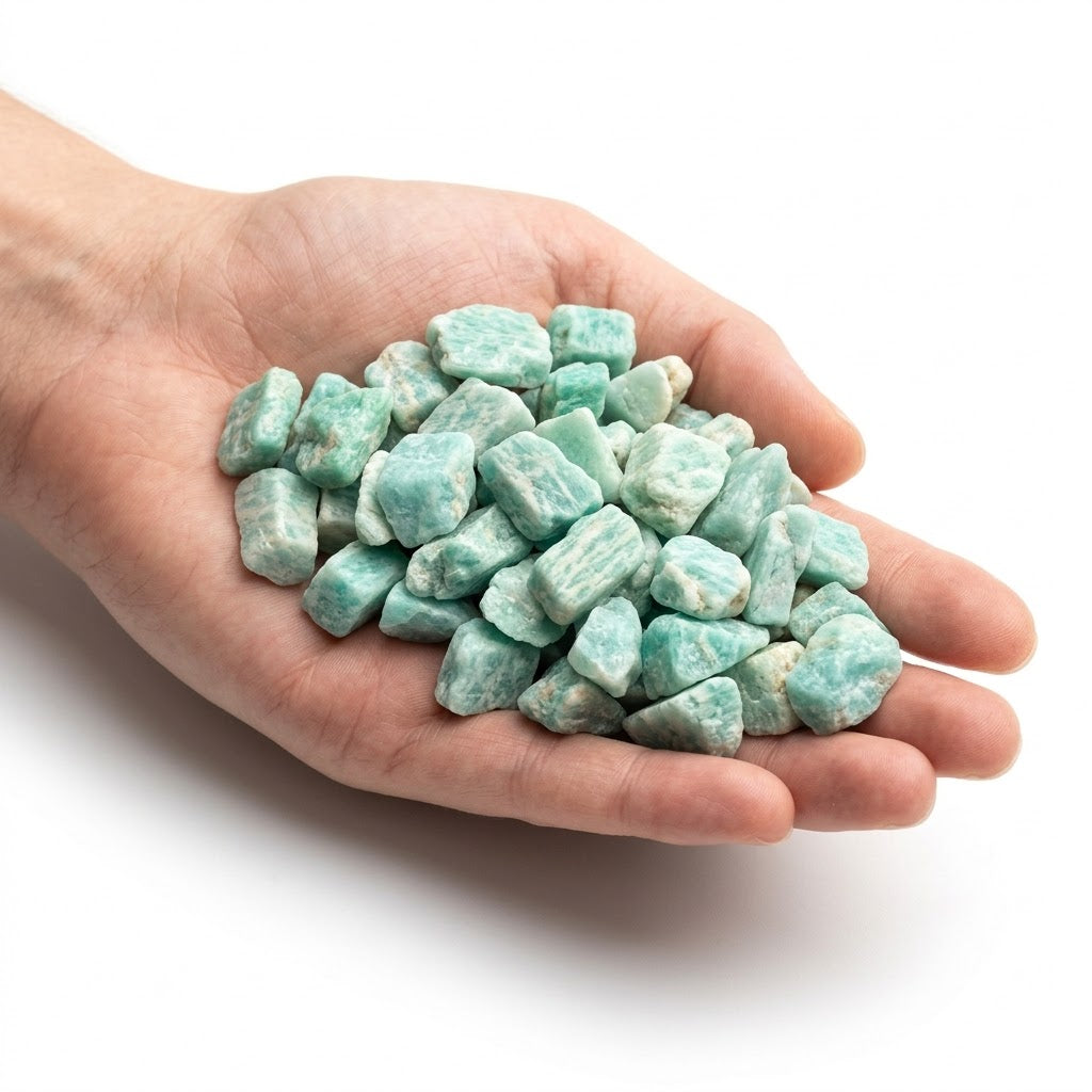 A hand holding a heap of natural raw amazonite chips on a white background