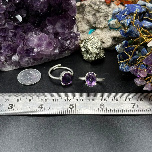 Natural amethyst adjustable ring with purple oval stone on black velvet, with coin and ruler background