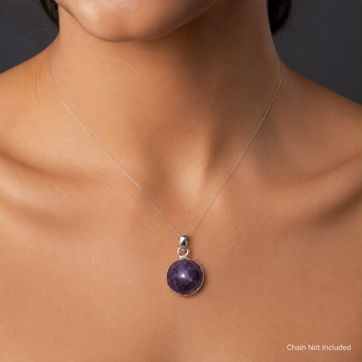 Natural amethyst cabochon pendant with German silver setting shown on model neckline