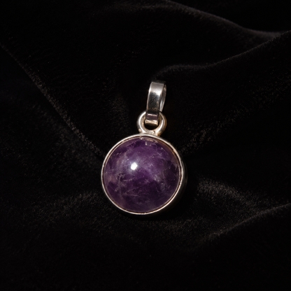 Natural amethyst cabochon pendant in German silver on black velvet background