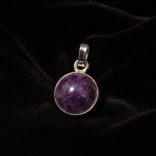 Natural amethyst cabochon pendant in German silver on black velvet background