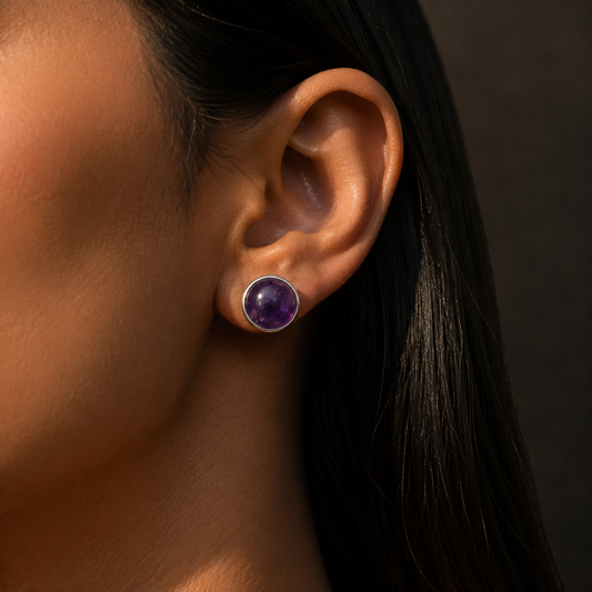 Natural amethyst cabochon stud earrings in German silver on a woman’s ear close-up