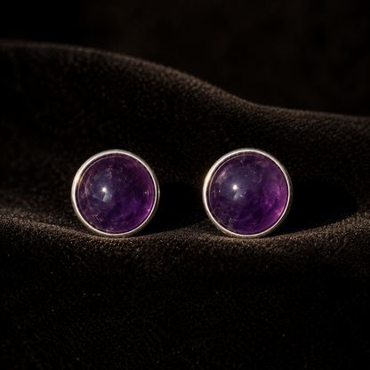 Natural amethyst cabochon stud earrings in German silver, pair view on dark textured surface