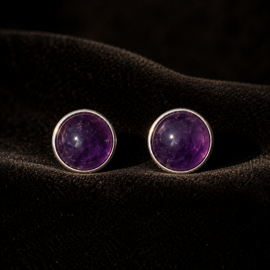 Natural amethyst cabochon stud earrings in German silver, pair view on dark textured surface