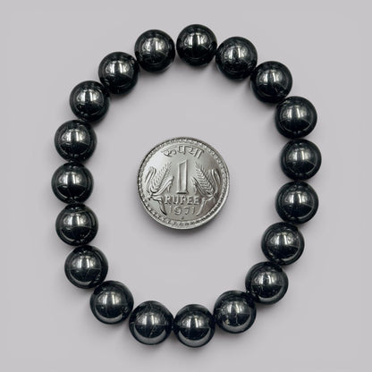 Natural black tourmaline bracelet beads with coin shown for size reference