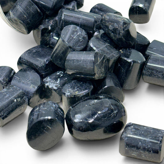 Natural black tourmaline tumble stones, close-up with glossy dark crystal faces