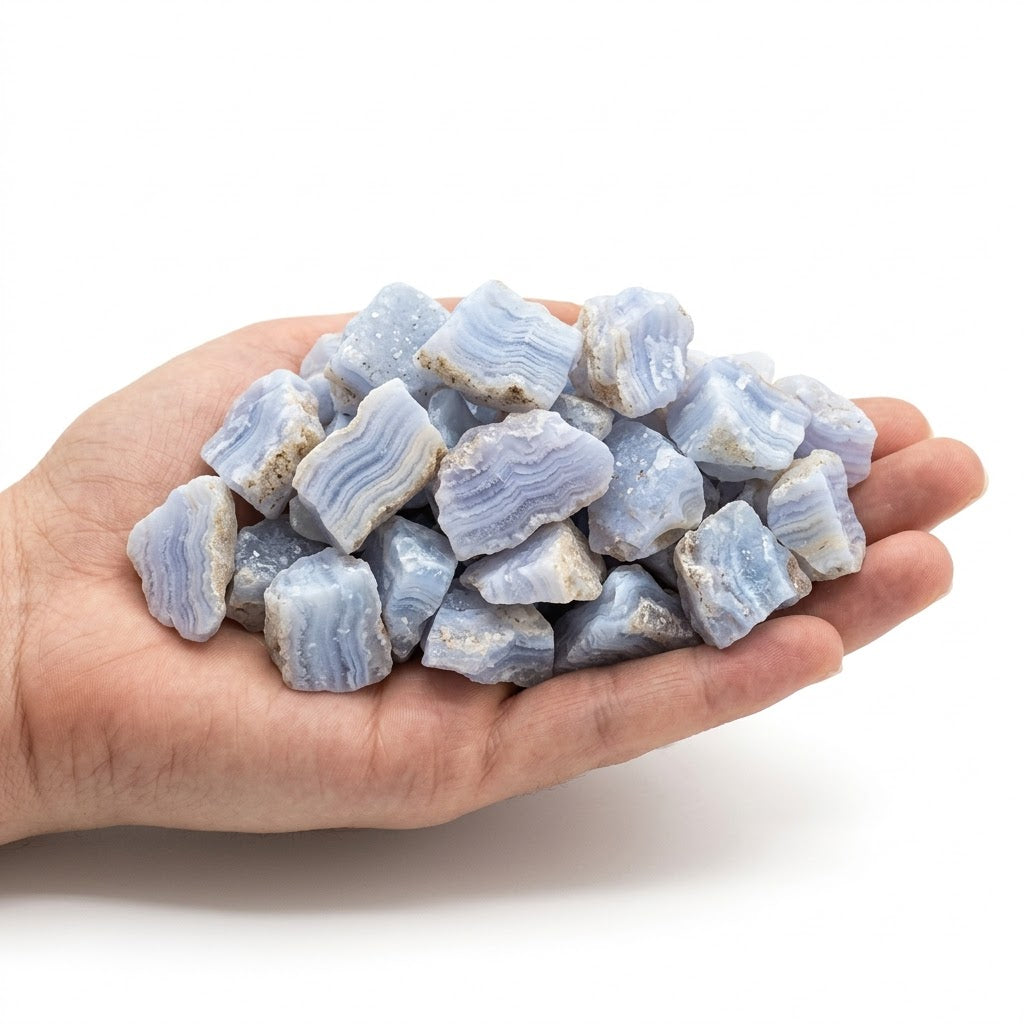 A hand holding a heap of natural raw blue lace agate chips on a white background