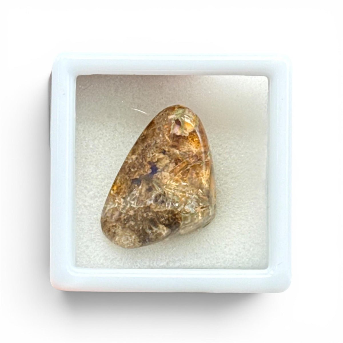 Natural boulder fire opal loose gemstone in a white display tray close-up
