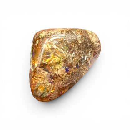 Natural boulder fire opal loose gemstone showing orange gold color and flashes