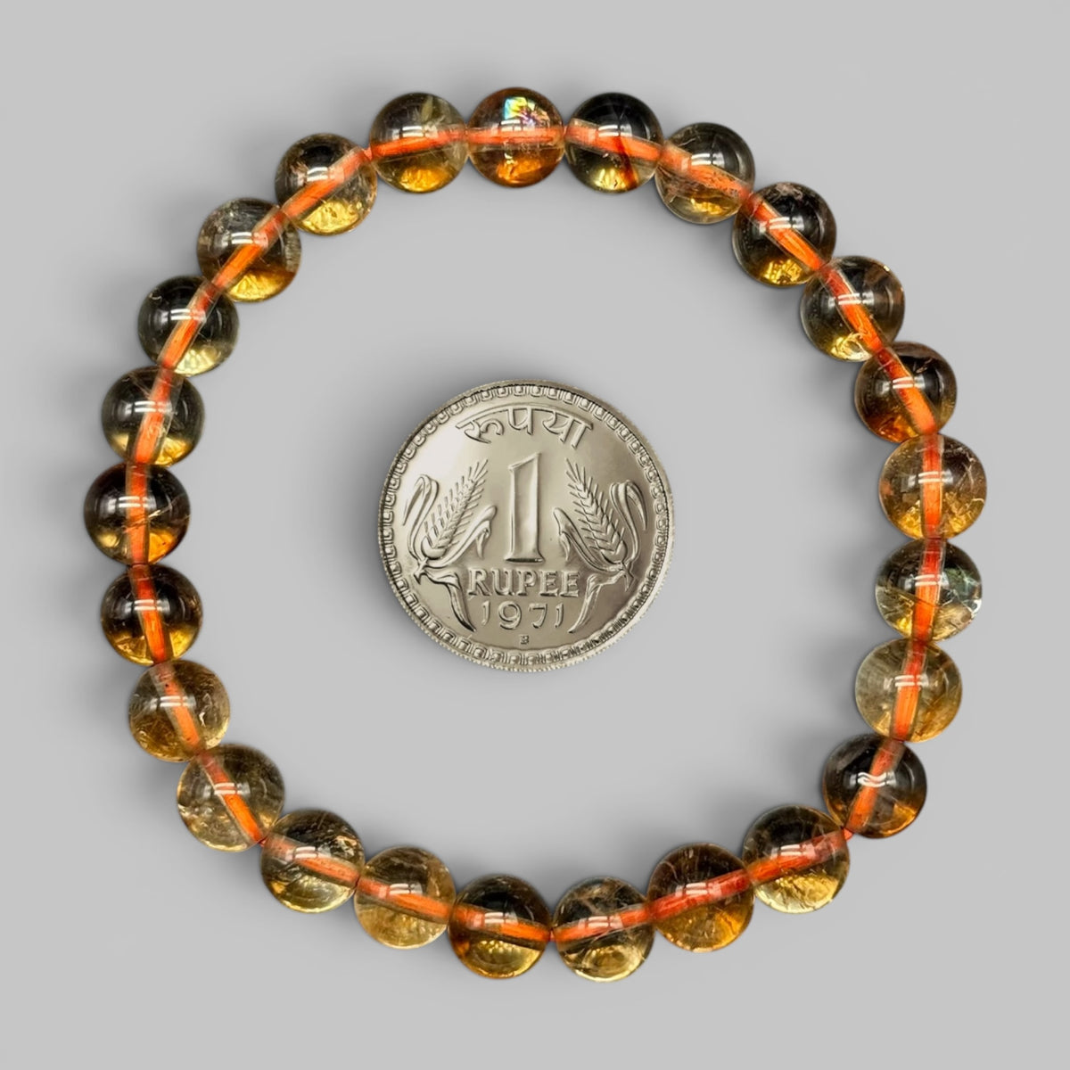 Natural citrine AAA bracelet shown beside rupee coin for size, with orange-red bead accents