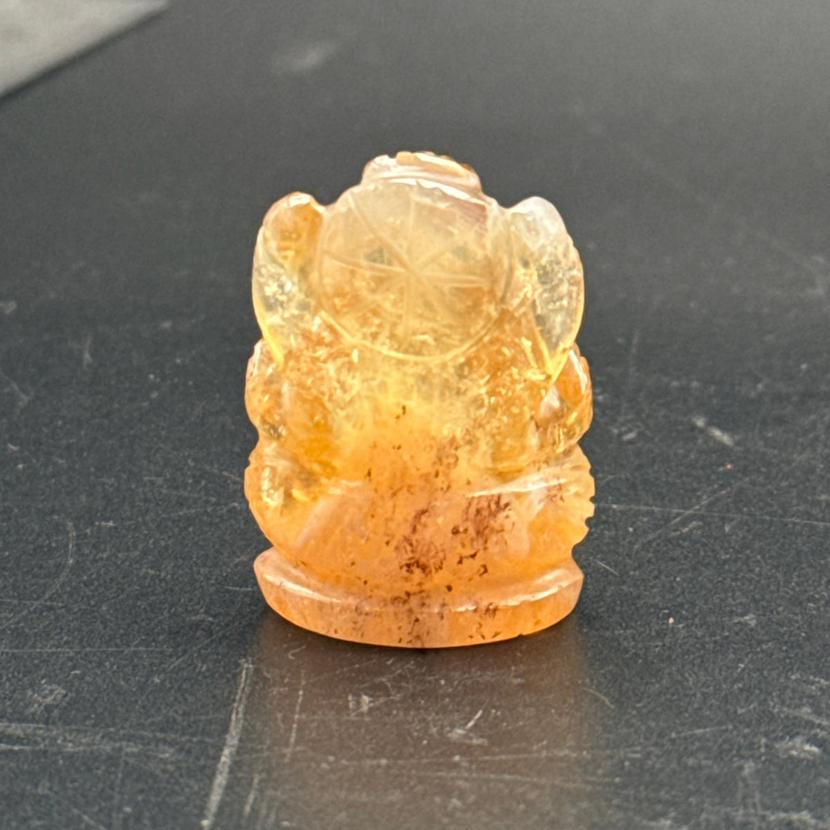 Natural citrine Ganesh Ji carving close-up from above, showing torso details