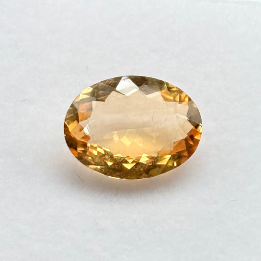 Natural citrine oval mixed cut gemstone close-up on white background