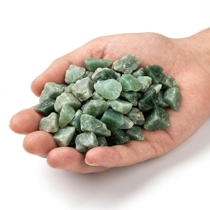 A hand holding a heap of natural raw green jade chips on a white background