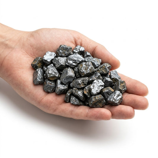 A hand holding a heap of natural raw hematite chips on a white background