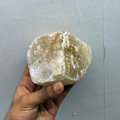 Natural honey calcite rough gemstone with white crystal areas on matrix