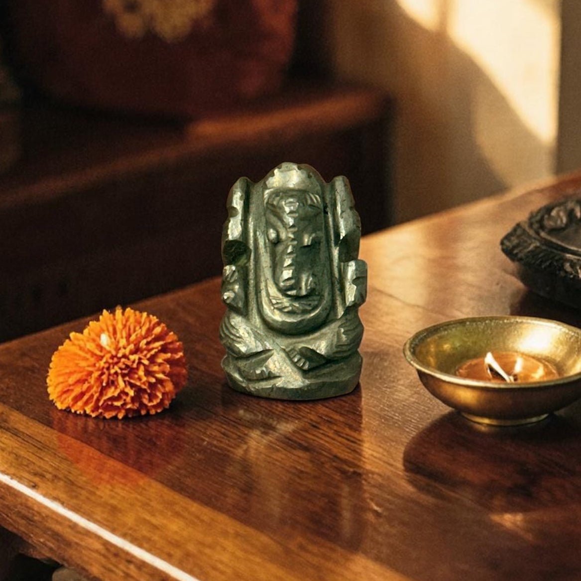 Natural pyrite Ganesh Ji carving figure standing with om-like details on wooden surface