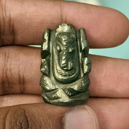 Natural pyrite Ganesh Ji carving figure held between fingers for a close-up view