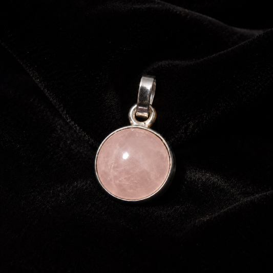Natural rose quartz cabochon pendant in German silver round bezel on black fabric