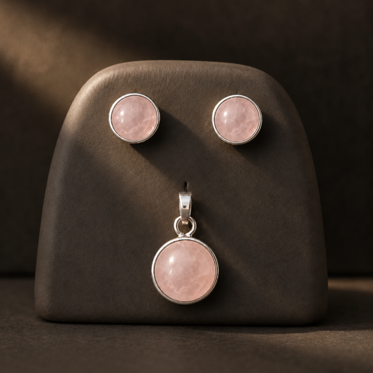 Natural rose quartz cabochon earring and pendant set in German silver on a jewelry display