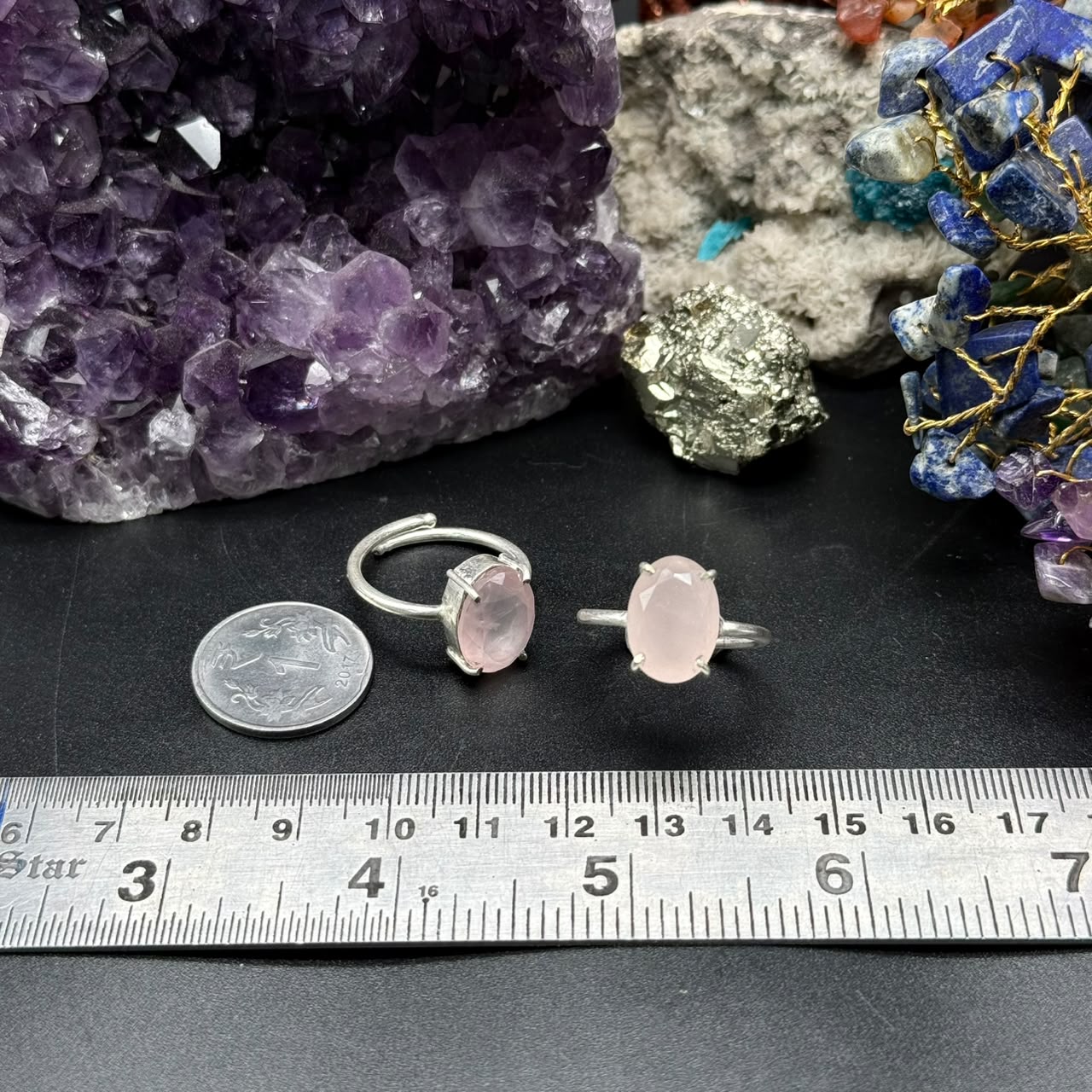 Natural rose quartz adjustable ring with pink oval stone on jewelry display and ruler