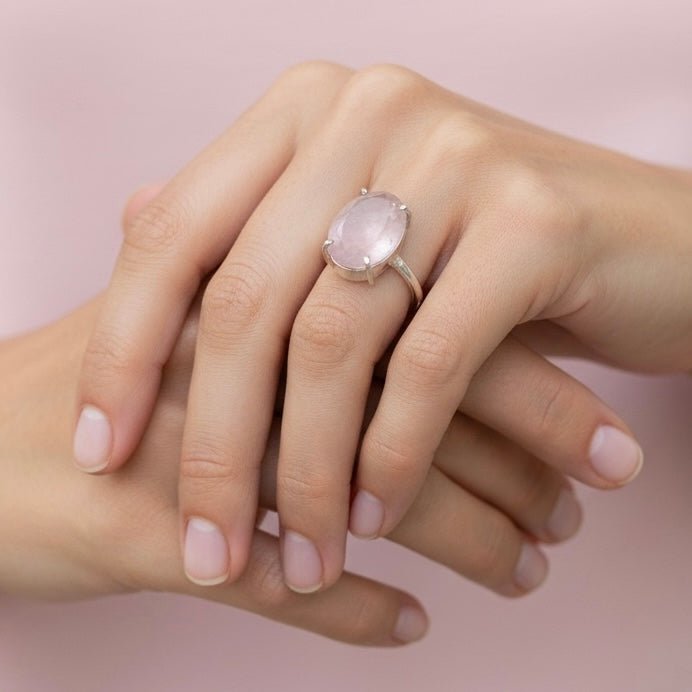 Natural rose quartz adjustable ring worn on hand with pink oval stone and silver setting