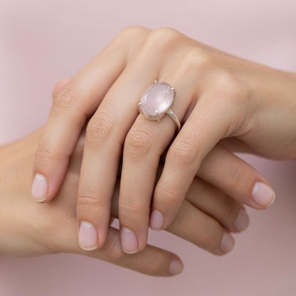 Natural rose quartz adjustable ring worn on hand with pink oval stone and silver setting