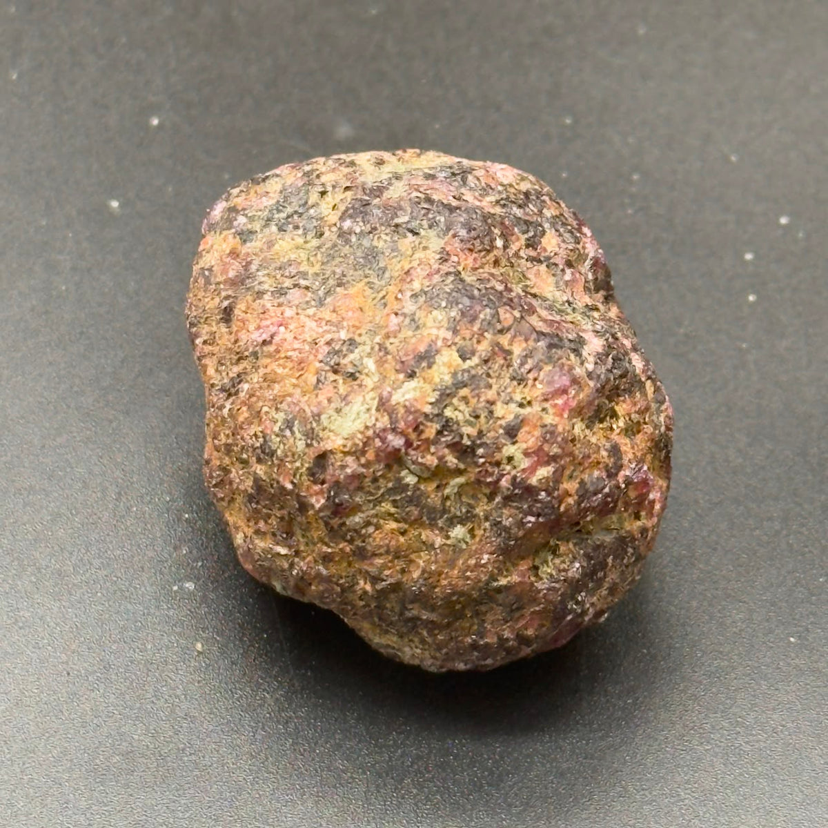 Natural rough hessonite garnet stone, rounded shape with speckled brown and green tones