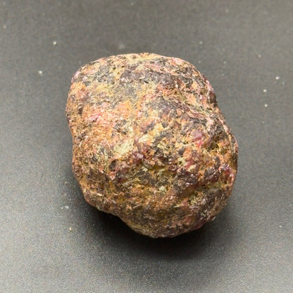 Natural rough hessonite garnet stone, rounded shape with speckled brown and green tones