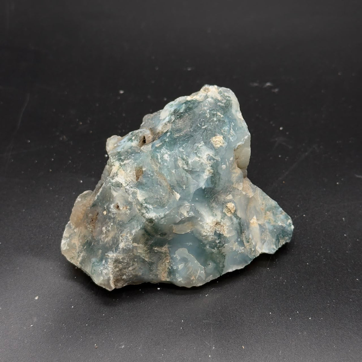 Natural rough moss agate stone with translucent blue-green color and jagged crystal edges