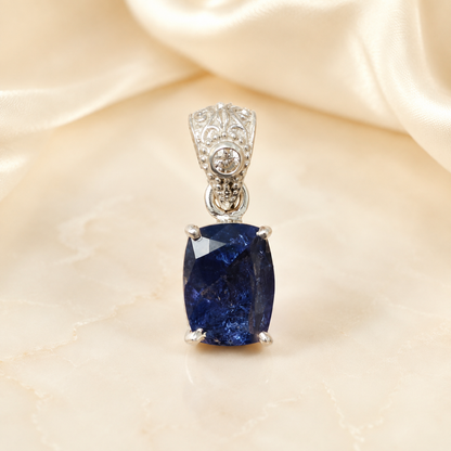 Natural tanzanite and lab-grown diamond pendant in 925 silver, close-up front view on light fabric