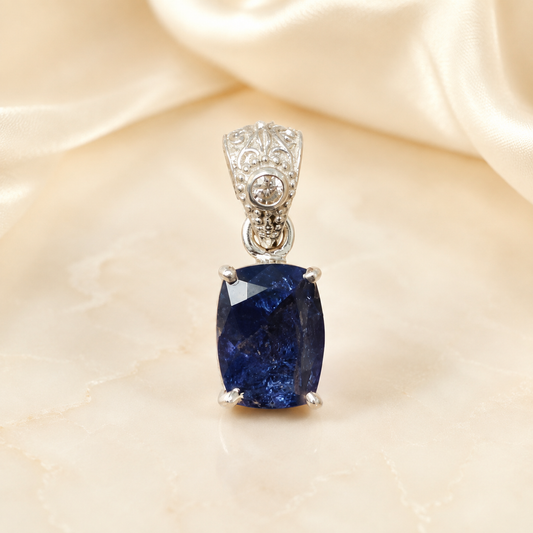 Natural tanzanite and lab-grown diamond pendant in 925 silver, close-up front view on light fabric