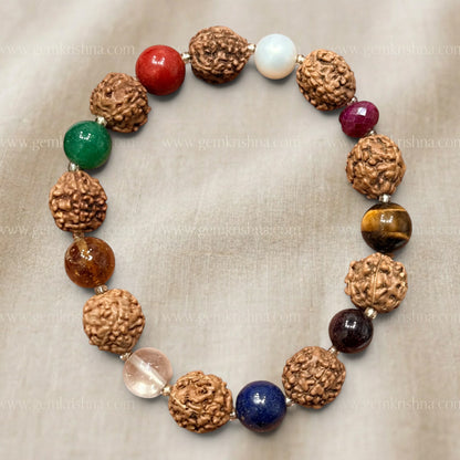Rudraksha bracelet beads with navratan gemstones close-up on gray fabric background