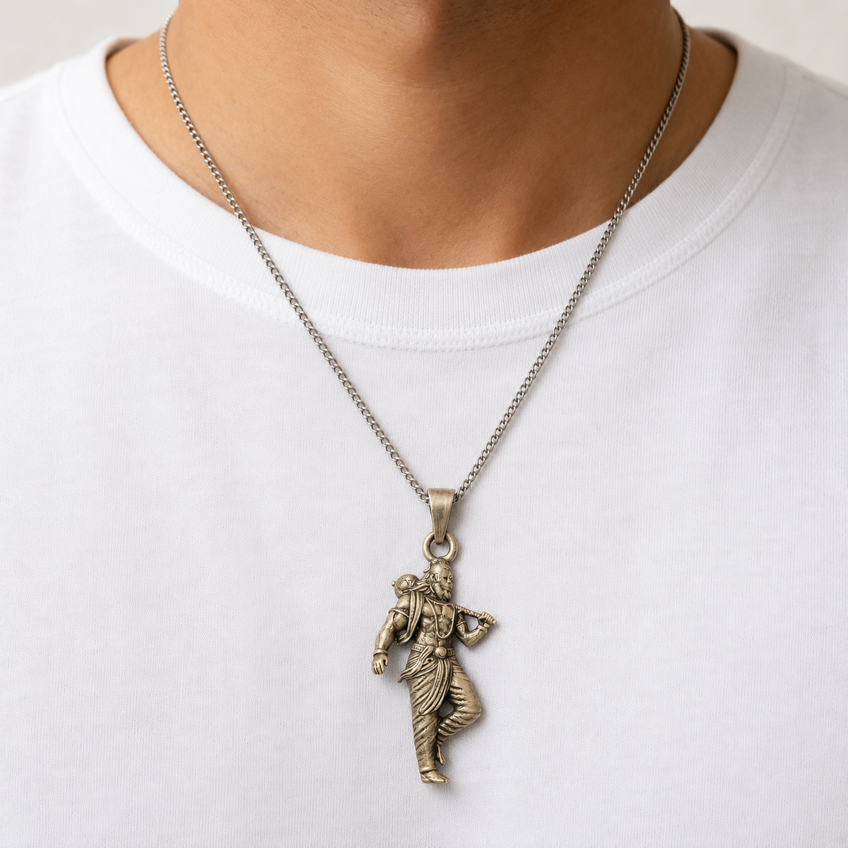 Lord Parashurama axe pendant worn on a silver chain against a white shirt