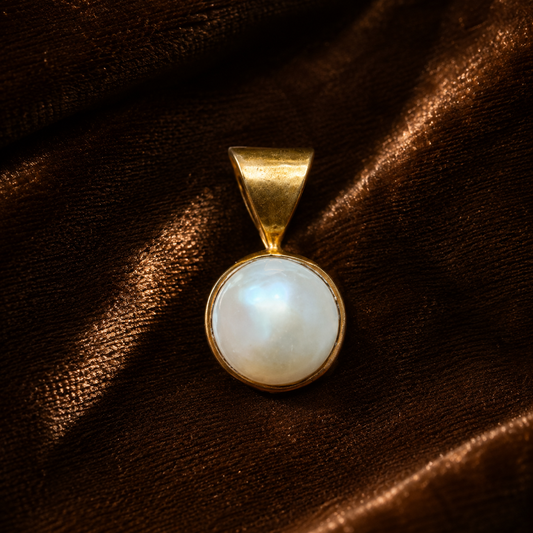 Pearl panchdhatu locket pendant with round mother-of-pearl style center on dark fabric
