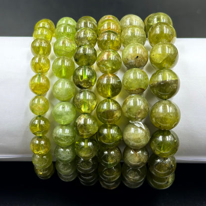 Close-up of peridot gem quality bracelet round green beads with glossy reflections