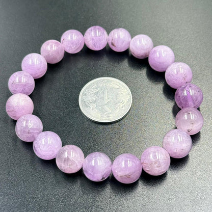 Pink Kunzite gemstone bead bracelet with round beads and visible size coin for scale
