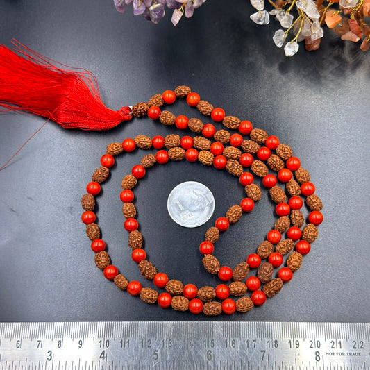 Layered view of red coral bead and rudraksha jap mala with red tassel and measuring coin