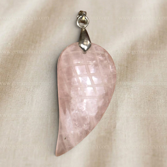Rose quartz feather-wing locket pendant close up with silver bail on light fabric