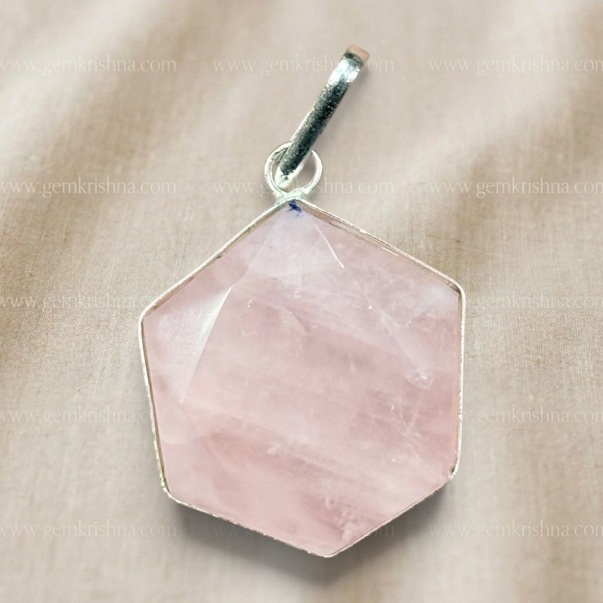 Rose quartz hexagon locket pendant close-up with hanging bail on light fabric