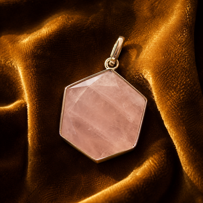 Rose quartz hexagon locket pendant with gold-tone frame on dark velvet