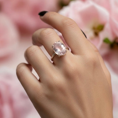 Natural rose quartz adjustable ring worn on hand with a pink oval stone and silver band