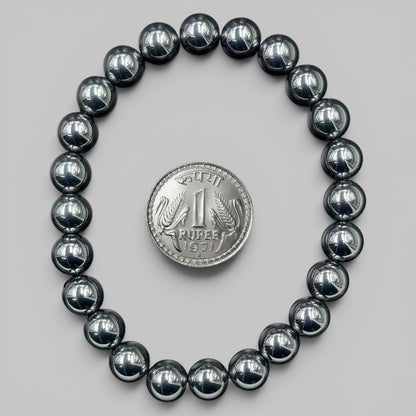 Shungite Elite bracelet view with shiny black round beads and rup ee coin for scale
