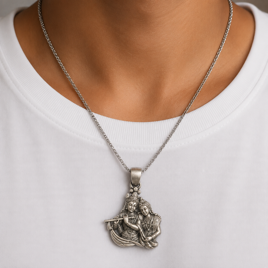 925 silver Radha Krishna flute pendant worn on a silver chain against white fabric