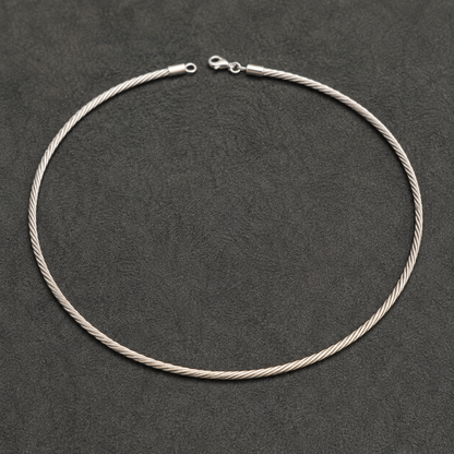 Silver Italian-style twisted hasli necklace with clasp and chain links laid on dark background
